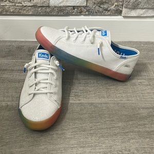 White canvas Keds with glittered tongue. Be the Change & bottom sole in rainbow.